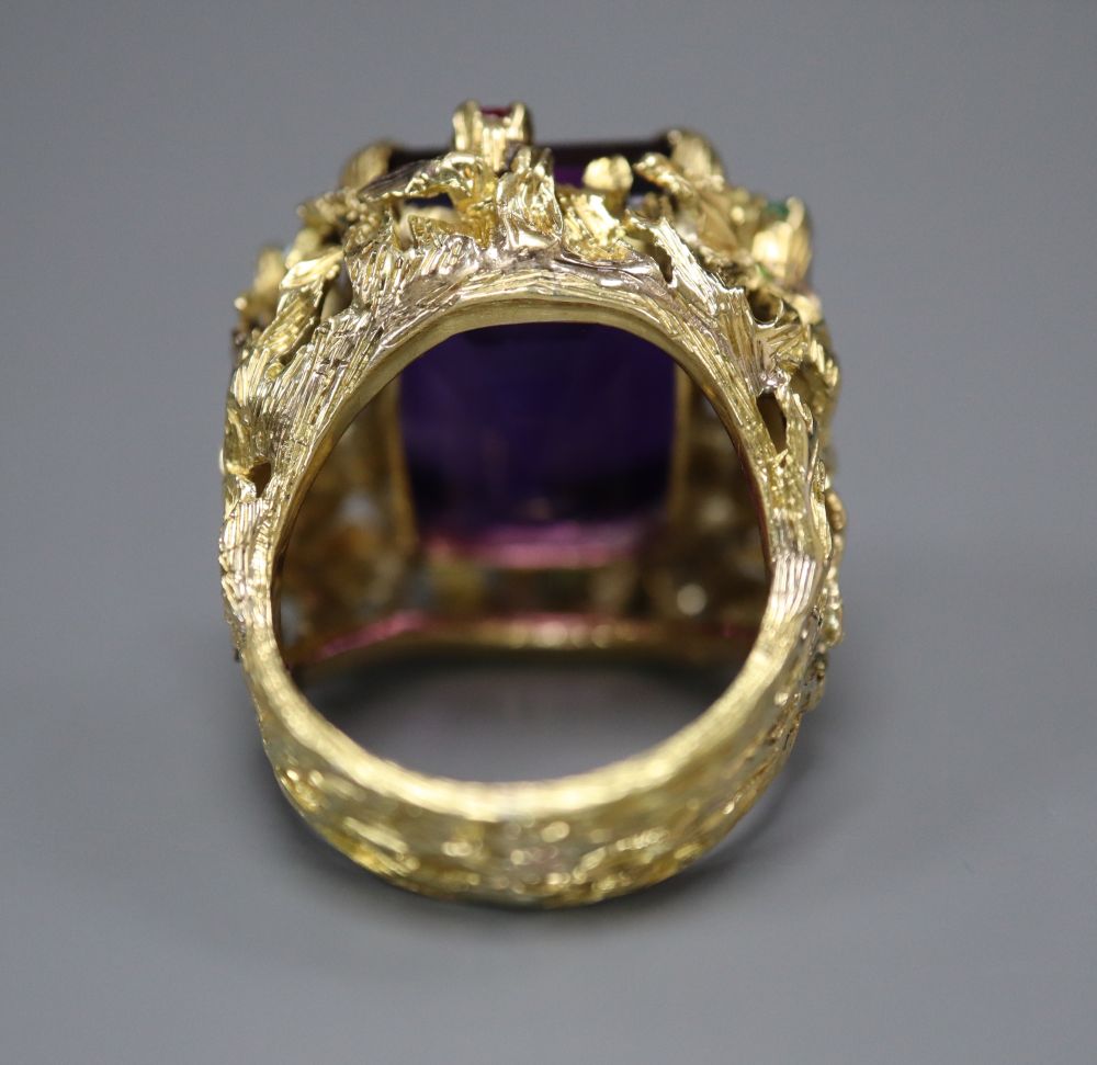 A yellow metal, amethyst, emerald and ruby cluster set naturalistic dress ring, size M, gross 20.9 grams.